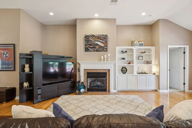 a living room with furniture a flat screen tv and a fireplace