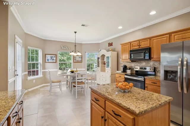 a kitchen with a stove a refrigerator and a dining table
