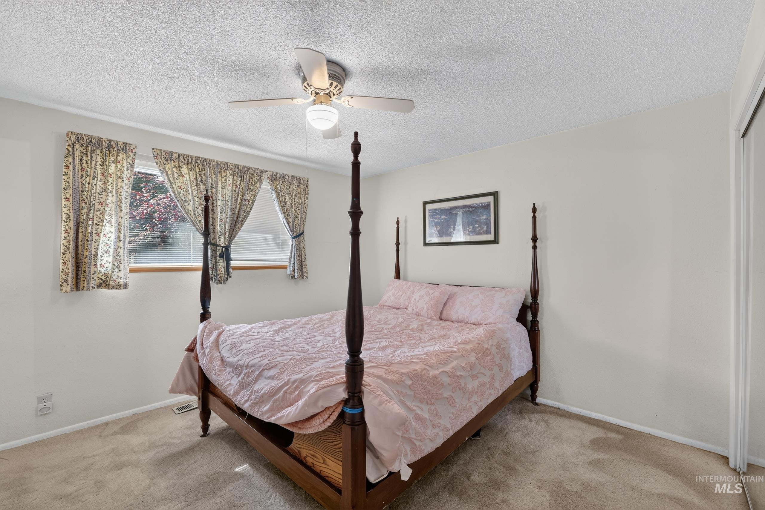 9055 West Highlander Road Boise, ID 83709 - Photo 18 of 39 Recessed window with wood trim, ceiling fan light fixture, wall-to-wall carpeting, and bi-fold closet doors