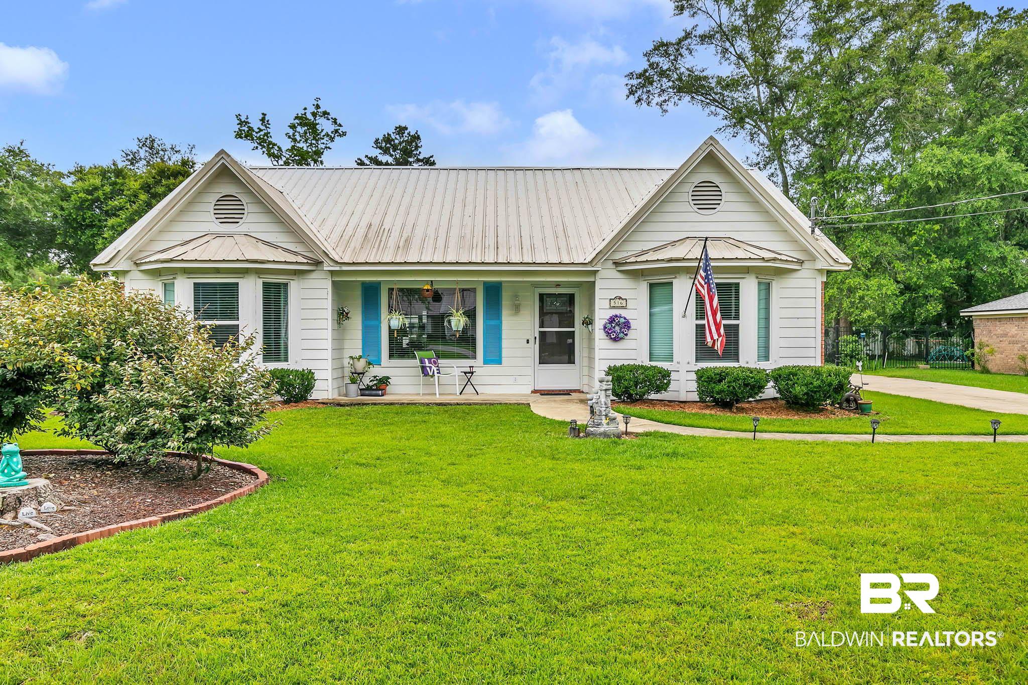 516 Juniper Place Drive Foley, AL 36535 - Photo 1 of 51 View of front of house with covered porch, a front lawn, and a metal roof