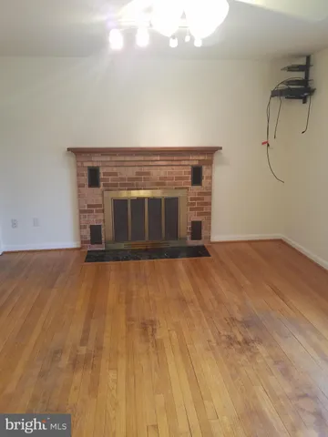 a view of empty room with wooden floor and fireplace