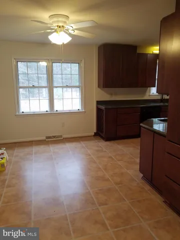 a kitchen with granite countertop a stove a cabinets and a counter top space