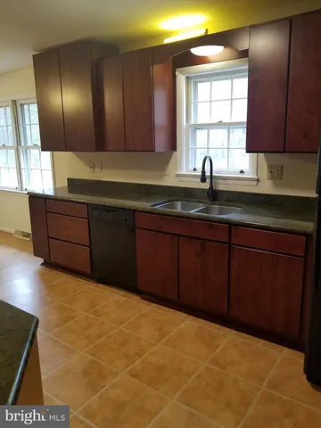 a kitchen with granite countertop a sink cabinets and window