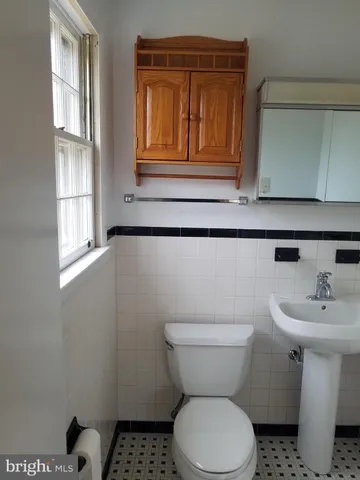 a bathroom with a sink a toilet and mirror