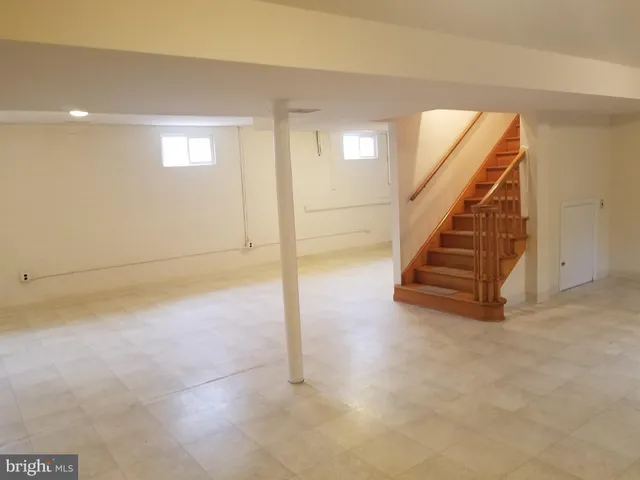 an empty room with staircase and white walls