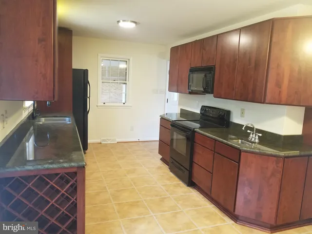 a kitchen with stainless steel appliances granite countertop wooden cabinets a stove top oven a sink and dishwasher