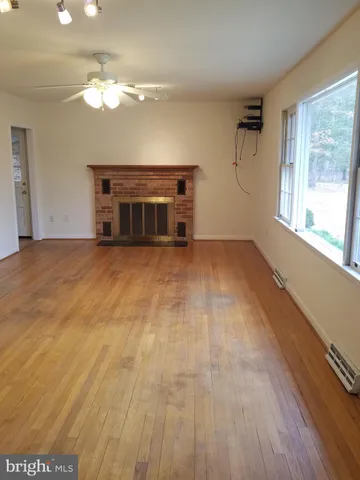 a view of a room with wooden floor and a fireplace