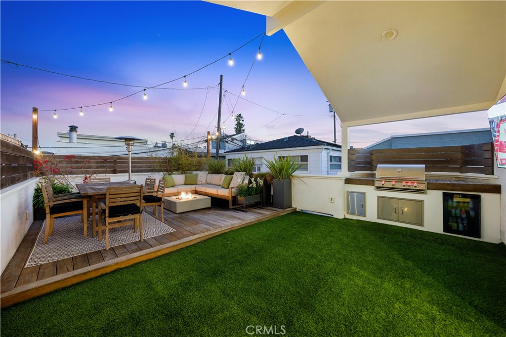 32 56th Place Long Beach, CA 90803 - Photo 17 of 49 a view of a patio with table and chairs with a barbeque grill and a yard