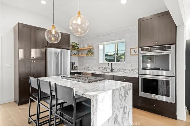 a kitchen with stainless steel appliances a stove a microwave a refrigerator and cabinets