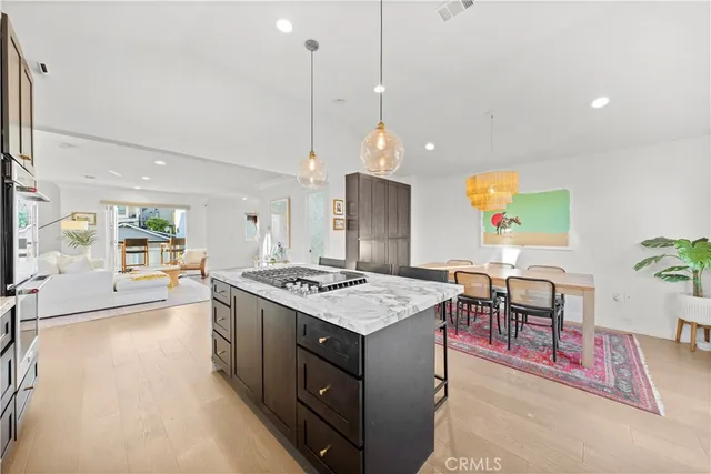 a open kitchen with stainless steel appliances granite countertop a stove and a view of living room