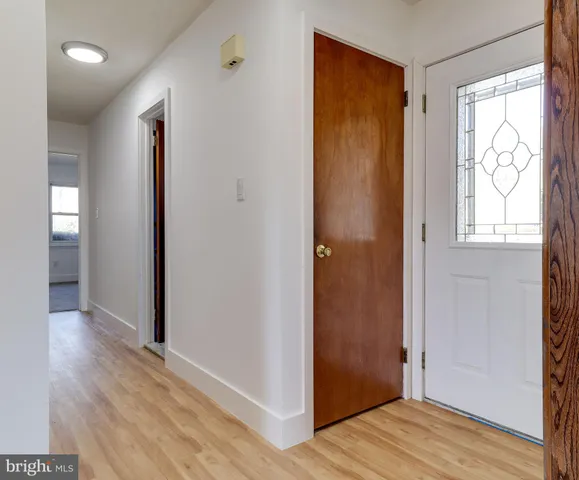 a view of a hallway with wooden floor and closet