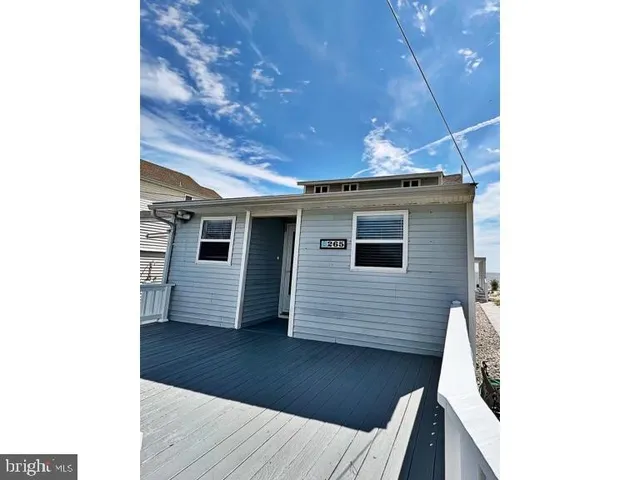 a view of a house with a small yard and large tree