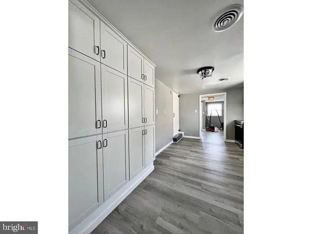 a large white kitchen with stainless steel appliances granite countertop a sink and cabinets