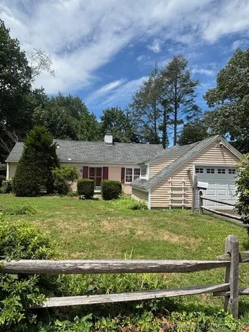 a view of a house with a big yard and potted plants
