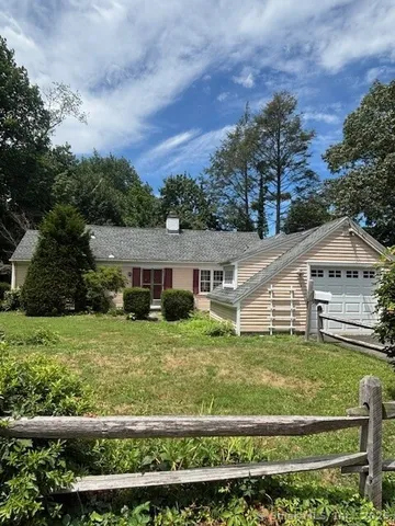 a view of a house with a big yard and large trees