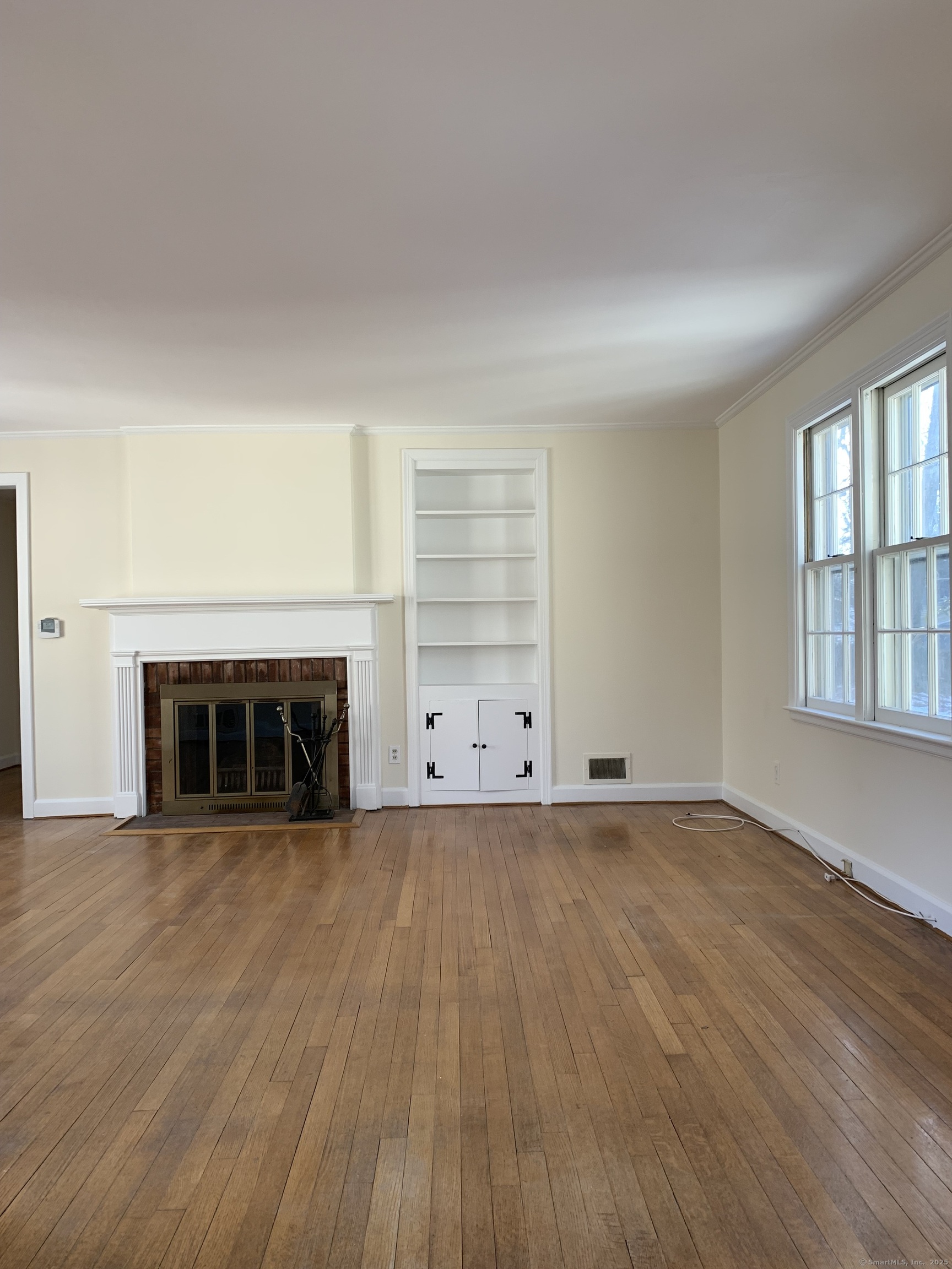 16 Garfield Avenue North Haven, CT 06473 - Photo 8 of 26 an empty room with wooden floor fireplace and windows