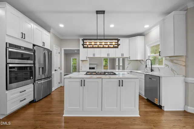 a kitchen with stainless steel appliances a stove a sink and a refrigerator