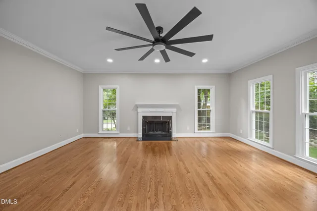 wooden floor fireplace and windows in an empty room