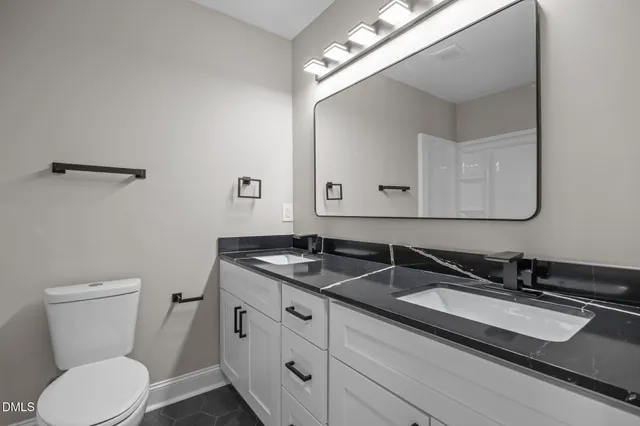 a bathroom with a toilet a sink and mirror