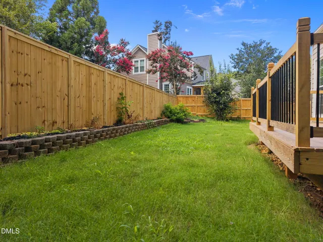 a view of a back yard with a wooden fence