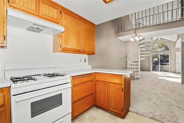 a kitchen with stainless steel appliances granite countertop a stove and a white cabinets