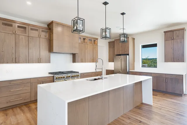 a kitchen with a sink a stove and a wooden floor