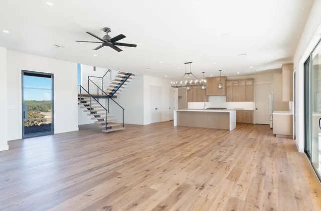 a view of an empty room with wooden floor and a fireplace