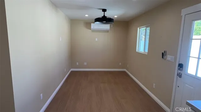 a view of a hallway with wooden floor and a chandelier