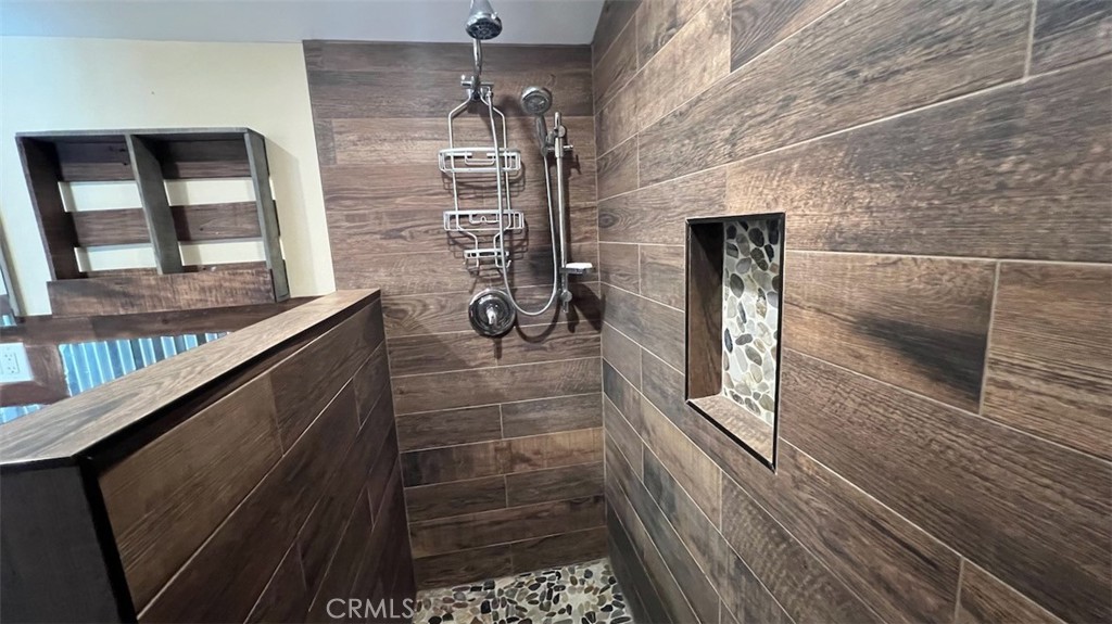 10908 Canby Avenue Porter Ranch, CA 91326 - Photo 24 of 26 a bathroom with a glass shower door and sink