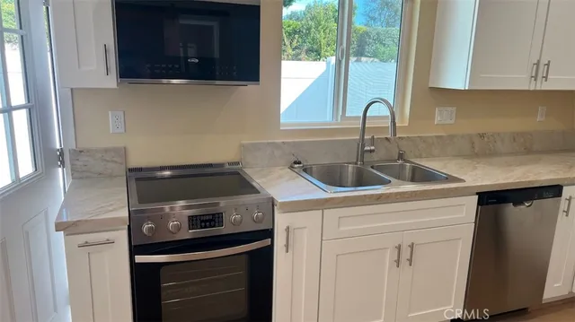 a kitchen with stainless steel appliances granite countertop a sink stove and cabinets