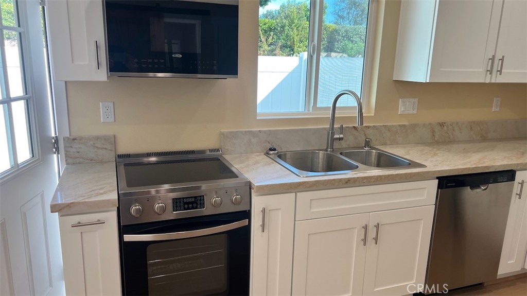 10908 Canby Avenue Porter Ranch, CA 91326 - Photo 6 of 26 a kitchen with a sink and cabinets