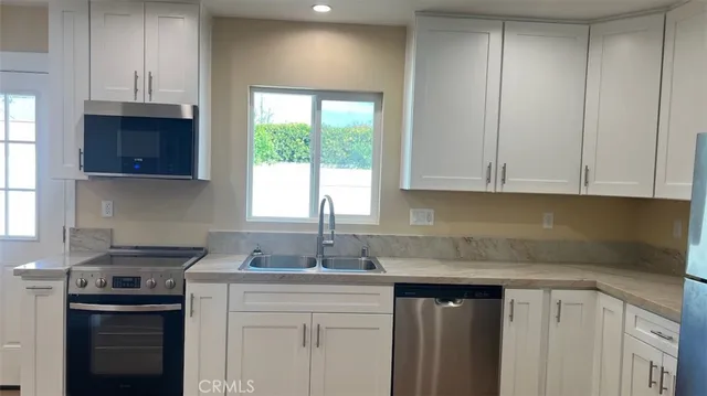 a kitchen with a sink a stove and cabinets