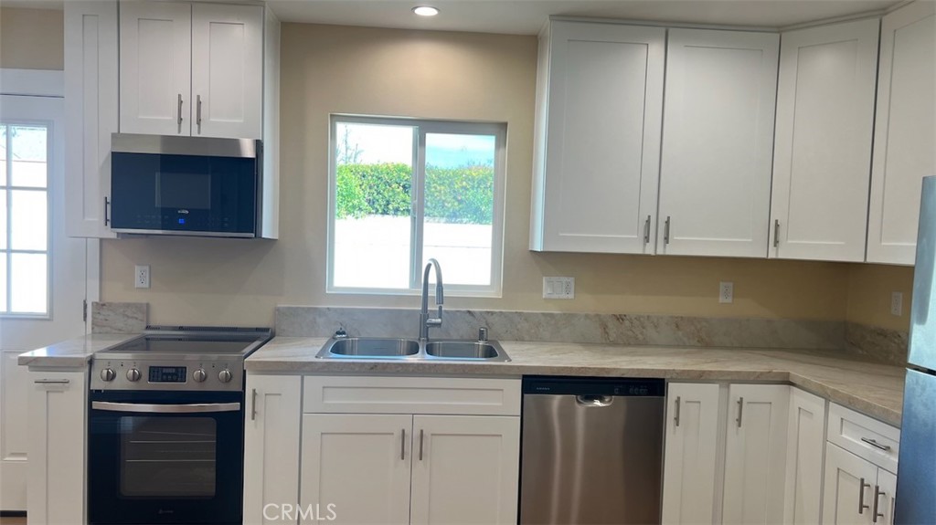 10908 Canby Avenue Porter Ranch, CA 91326 - Photo 7 of 26 a kitchen with stainless steel appliances granite countertop a sink stove and cabinets