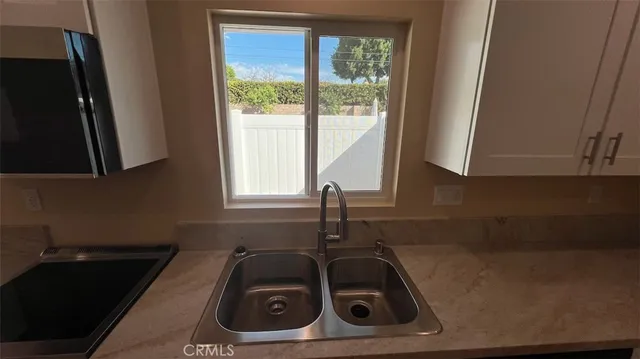 a kitchen with a refrigerator sink and cabinets