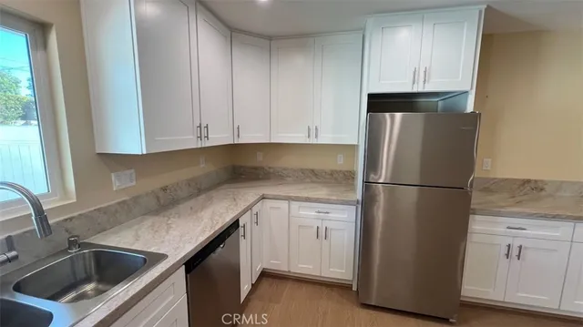 a kitchen with stainless steel appliances granite countertop a refrigerator a sink a stove a microwave and wooden cabinets