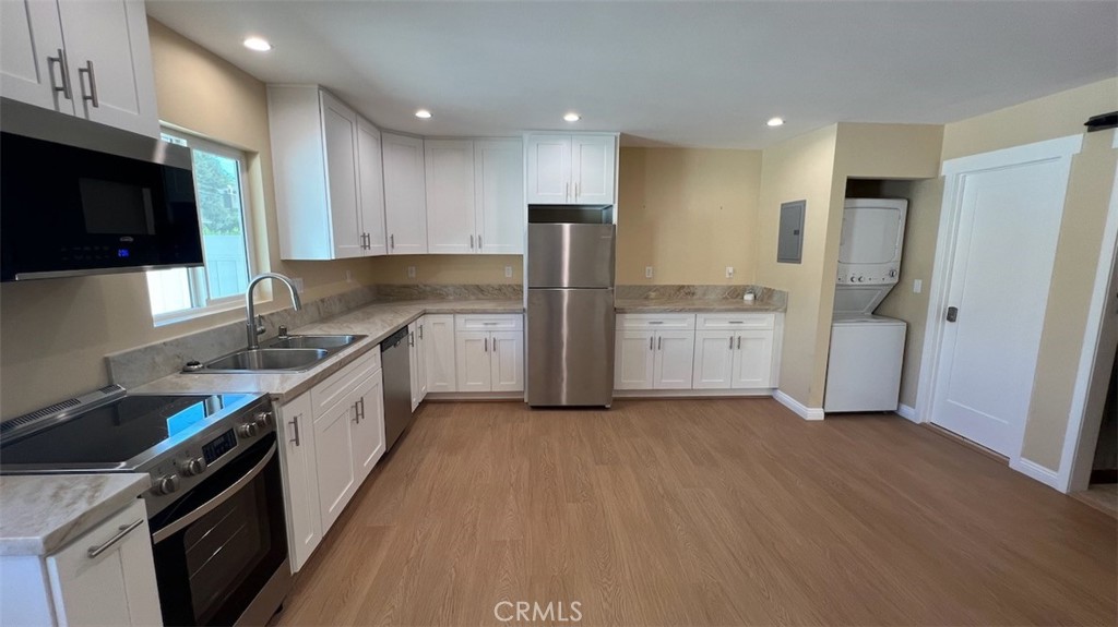 10908 Canby Avenue Porter Ranch, CA 91326 - Photo 10 of 26 a kitchen with stainless steel appliances granite countertop a refrigerator a sink a stove a microwave and wooden cabinets
