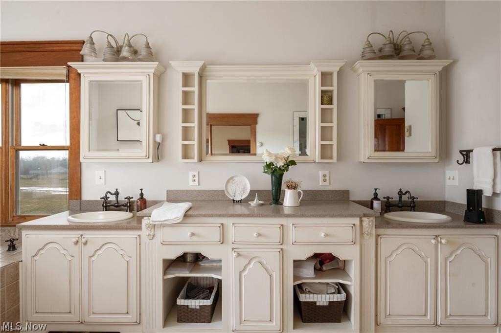 9419 Robinson Road Chardon, OH 44024 - Photo 22 of 49 Dual vanity with off-white cabinetry, integrated sinks, and polished countertops