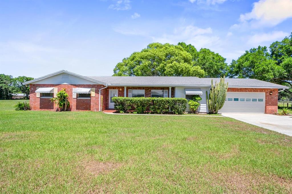 18110 Dorman Road Lithia, FL 33547 - Photo 1 of 1 a front view of a house with a yard and garage