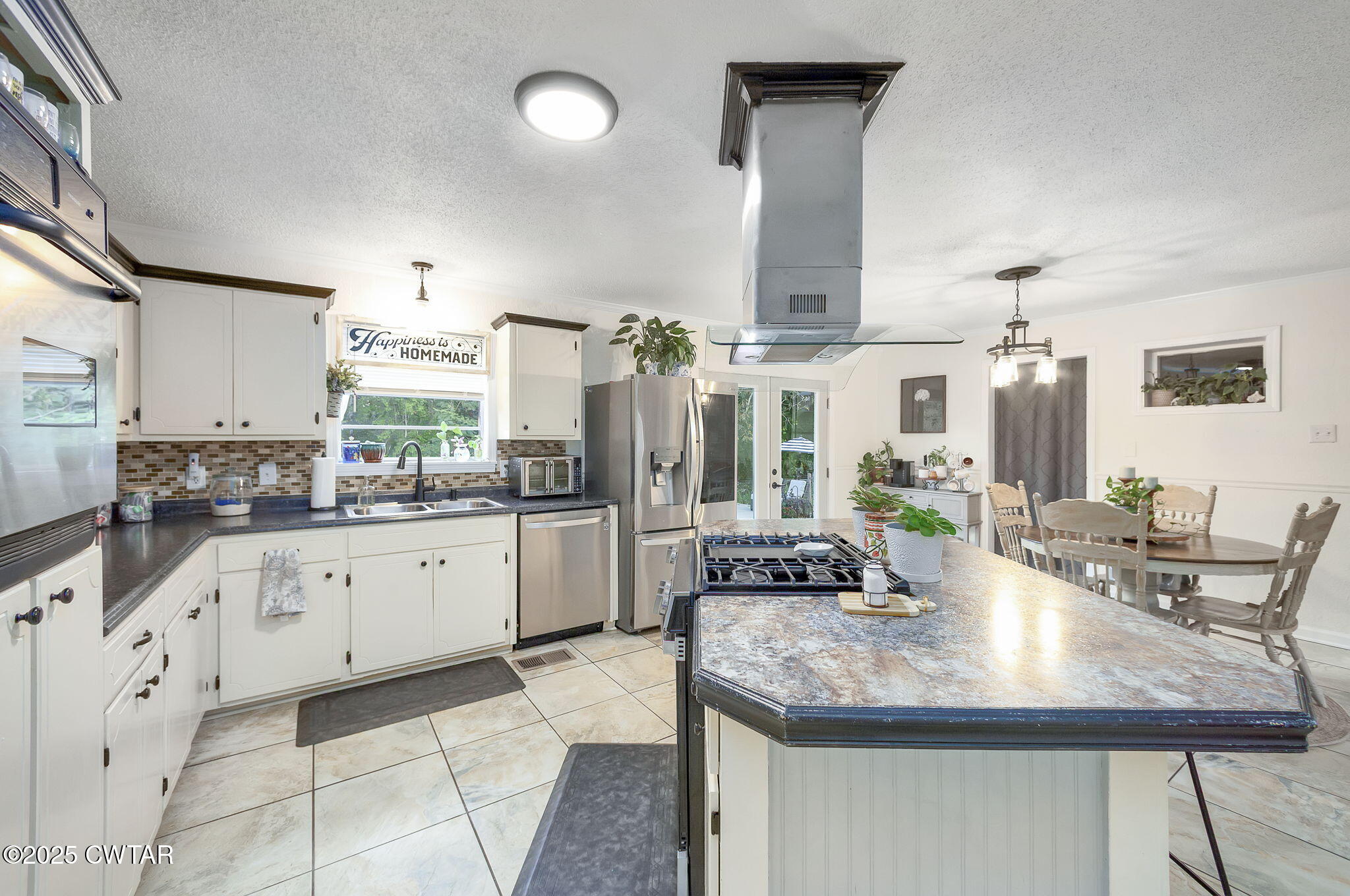 2735 Blue Goose Road Huron, TN 38345 - Photo 7 of 51 a kitchen with granite countertop a sink white cabinets and chairs