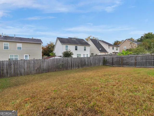 a view of a house with a yard and wooden fence