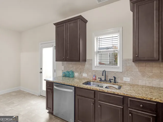 a kitchen with granite countertop a sink cabinets and window