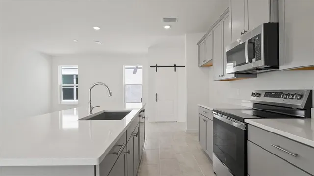 a kitchen with white cabinets and refrigerator