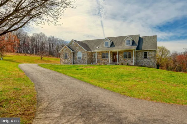 a view of a house with a big yard and large trees