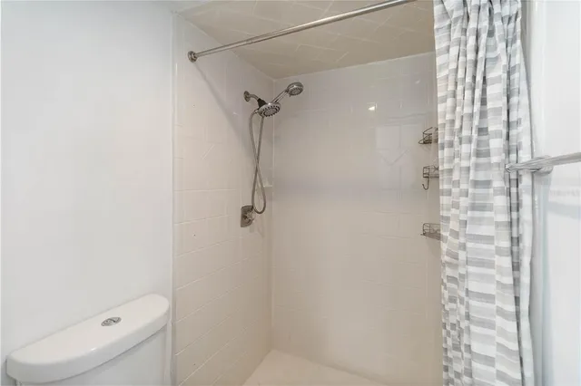 a bathroom with a granite countertop shower and a toilet