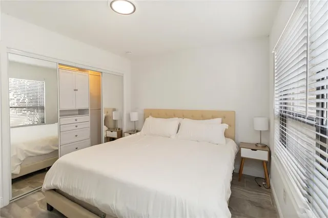 a bedroom with a bed and a large window