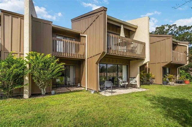 a view of a house with table and chairs in patio
