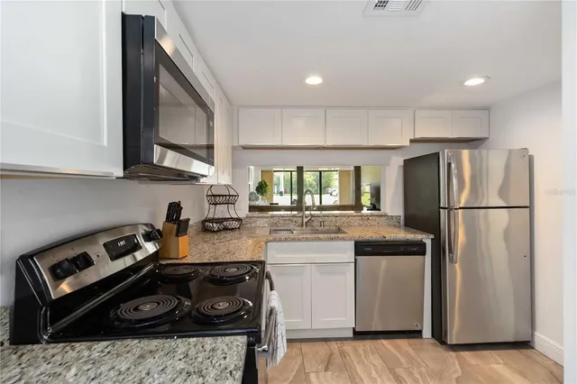 a kitchen with stainless steel appliances granite countertop a stove a refrigerator and a stove
