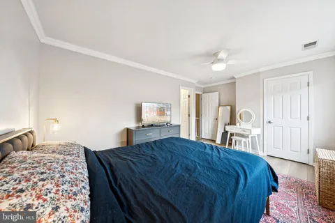 a bedroom with a large bed and a chandelier
