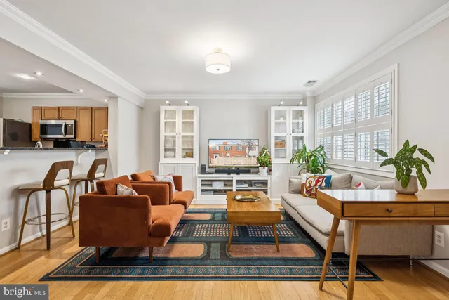 a living room with furniture a flat screen tv and a table