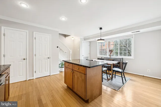 a dining hall with stainless steel appliances granite countertop furniture and wooden floor
